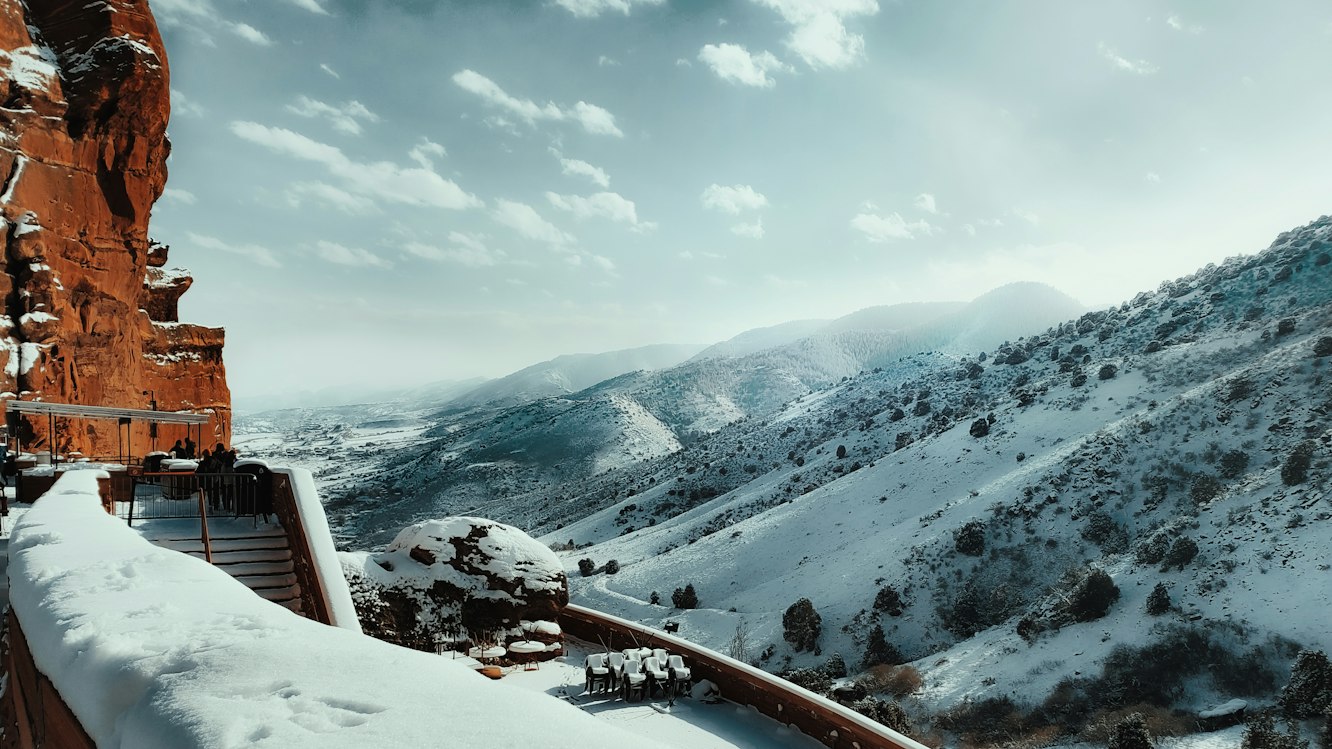 Snow-covered hills and red sandstone cliffs at Red Rocks near Denver, Colorado.