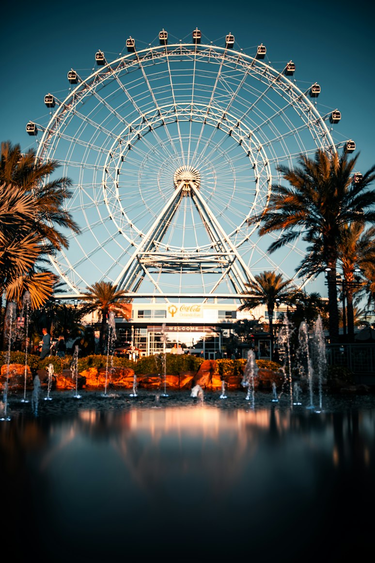 The observation wheel at ICON Park in Orlando, framed by palms and fountains.
